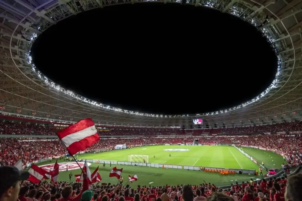 Free Exciting soccer match with enthusiastic fans in a packed stadium under bright lights. Stock Photo
