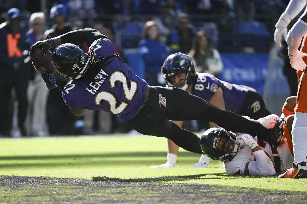 Nov 3, 2024; Baltimore, Maryland, USA; Baltimore Ravens running back Derrick Henry (22) dives over Denver Broncos safety Brandon Jones (22) tackle attempt for a touchdown during the first quarter at M&T Bank Stadium. Mandatory Credit: Tommy Gilligan-Imagn Images