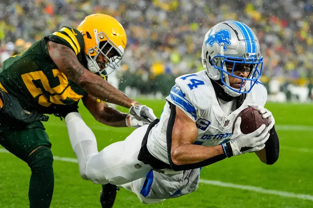Detroit Lions wide receiver Amon-Ra St. Brown (14) makes a catch for a touchdown against Green Bay Packers cornerback Keisean Nixon (25) during the first half at Lambeau Field in Green Bay, Wis. on Sunday, Nov. 3, 2024.