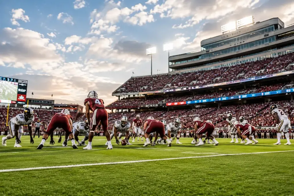 rnadom generic college football scene with on-field look at stadium in background